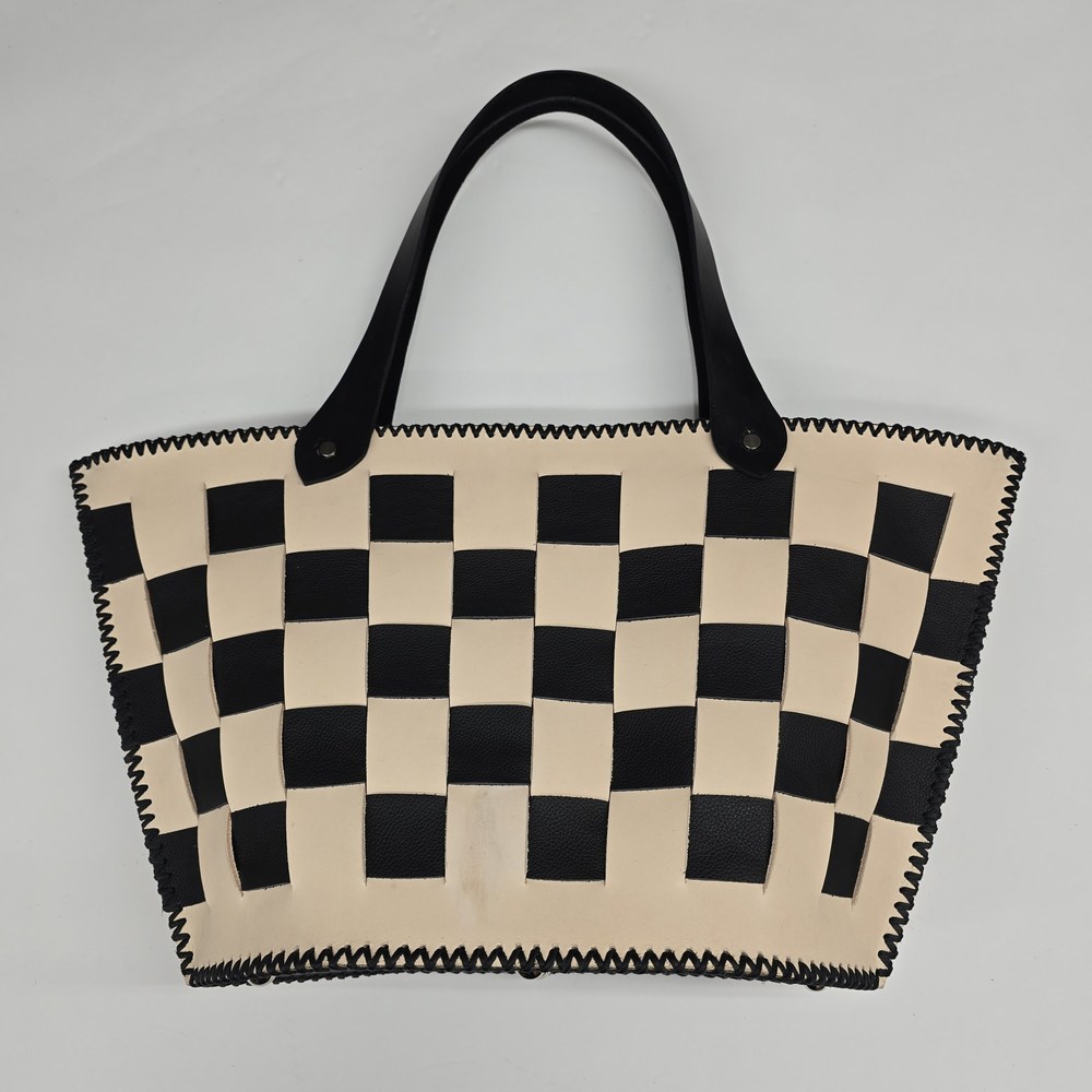 Front view of Equilibre, a cream and black checked tote with black handles and stitched edges.