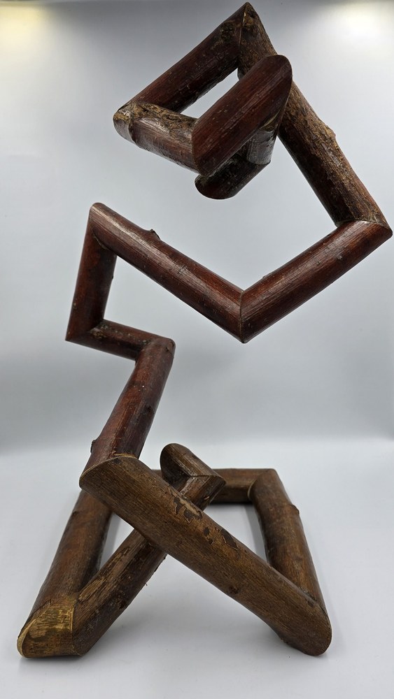 Interradis, an open angular wooden sculpture photographed upright against a light background.